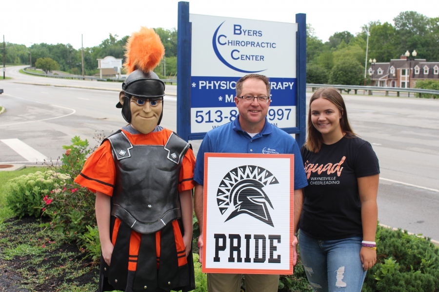 spartan mascot and three people holding a sign